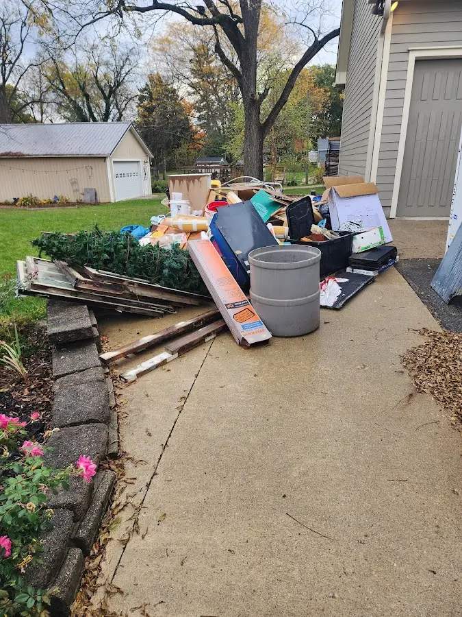 Dumpster being loaded with debris for Estate Cleanout Dumpster Rental in Mendon